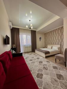 阿拉木图Bastau Hotel的一间大卧室,配有一张床和红色地毯
