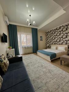 阿拉木图Bastau Hotel的一间大卧室,配有一张床和一张沙发