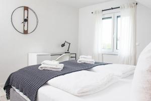 罗拉赫BlackNCozy - Design Appartement mit Boxspringbett und Balkon的白色的卧室配有一张床和墙上的时钟