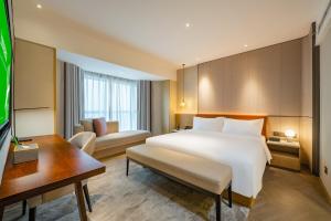 上海上海华夏假日酒店的酒店客房设有一张白色大床和一张书桌