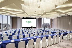 上海上海华夏假日酒店的大房间设有椅子和投影屏幕