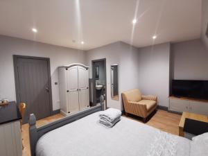 利物浦Shared house close to Liverpool city center & LFC/EFC的一间卧室配有一张床、一台电视和一把椅子