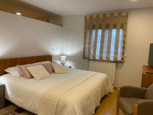 吉马良斯Quinta Picouto de Cima的卧室配有床、椅子和窗户。