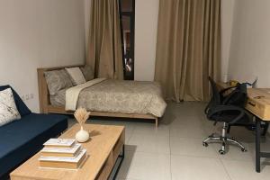 沙迦luxury 1 BR studio in Sharjah的客厅配有床、书桌和书桌