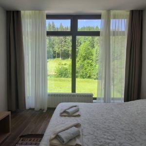 新瓦罗什Zlatarska dolina的一间卧室设有一张床和一个大窗户