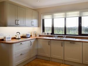 BeithHillview的厨房配有白色橱柜、水槽和窗户。