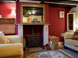 阿什比圣勒杰斯Rebeccas Cottage的客厅设有壁炉和镜子