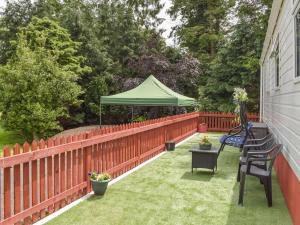 AnnbankTranquillity Lodge的一个带围栏和绿色遮阳伞的庭院