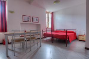 Sernio塞尔尼奥托酒店的一间卧室配有红色的床和桌椅