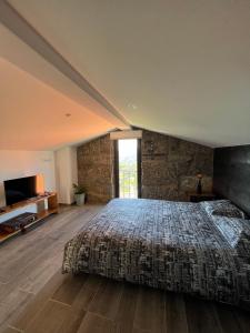 雷森迪Casas do Monte的一间卧室设有一张带石墙的大床