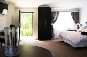 伊登维尔La Coscello Guest House的酒店客房设有床、桌子和窗户。