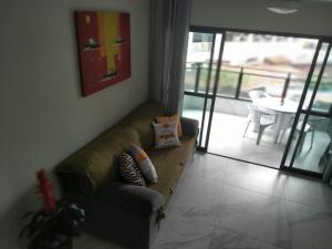 瓜鲁雅Apartamento Guarujá Astúrias的客厅配有带枕头的沙发
