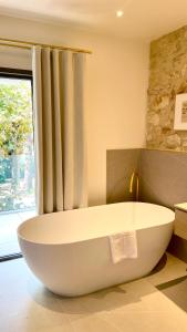 蒙彼利埃La Maison Verchant的带窗户的浴室内的白色大浴缸