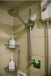 马尼拉WestParc Cedar Alabang的浴室设有淋浴,墙上有两个架子