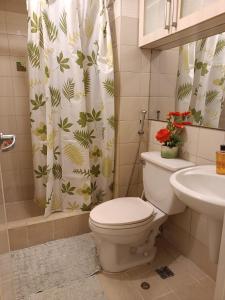 马尼拉WestParc Cedar Alabang的浴室设有卫生间、水槽和淋浴帘