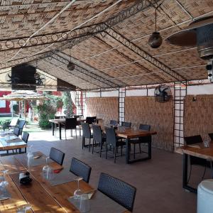 马拉喀什Résidence Habiba的餐厅设有木桌和椅子以及大型天花板。
