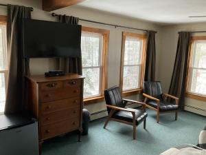 LovellThe Lodge at Pleasant Point的一间卧室配有带电视和2把椅子的梳妆台