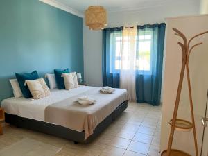 里戈尔Herdade da Vagem的一间卧室配有一张蓝色墙壁的床和一扇窗户