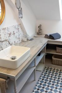 塔布La Maison de Sylvie, chambres d'hôtes à Tarbes的木制柜台上带水槽的浴室