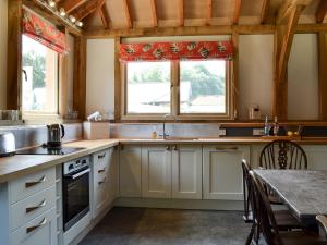福丁布里奇Little Barn - Ukc2539的厨房配有白色橱柜、桌子和窗户。
