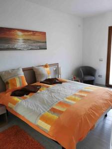 瓦雷多利亚Apartment - Il Paradiso - where dreams come true的一间卧室配有一张带橙色棉被的大床