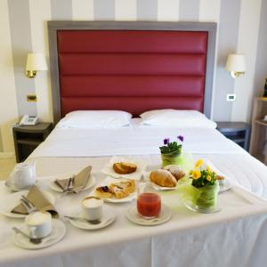 卡夏精华大酒店的床上的桌子和食物托盘