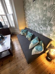 伦敦Beautiful ground floor garden flat的客厅配有带枕头的黑色沙发
