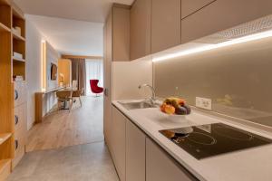 伯尔尼NEW OPENING 2022 - Los Lorentes Hotel Bern City的厨房配有水槽和柜台上的一碗水果