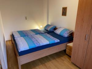 巴特恩多夫Ferienwohnungen Gmeiner的一张带蓝色床单和枕头的床