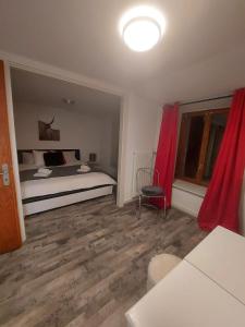 Le ChatelardLES TOURISTES的一间卧室配有床和红色窗帘