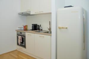 维也纳White Lotus Apartment的厨房配有白色冰箱和水槽