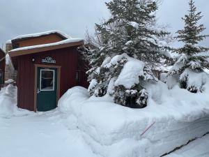 西黄石费斯街度假屋的雪覆盖的树在小棚前