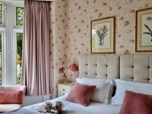 约克乔治之地旅馆的卧室配有白色床和粉红色花卉壁纸