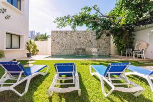 坎昆Viento Suites Cancún的一个带两把椅子的庭院和一个喷泉