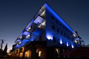 歌珊Orange Inn Boutique Hotel的一座晚上有蓝色灯光的建筑
