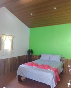 Hacienda GuayaboPochote Lodge的一间卧室配有一张带绿色墙壁的床