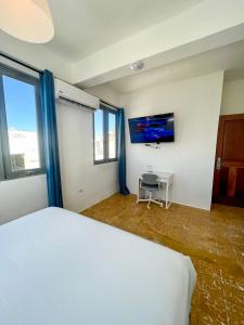 圣胡安Urbana Hotel的卧室配有白色的床和电视