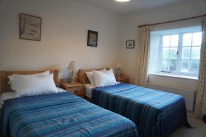 切尔滕纳姆The Snicket - Traditional Cotswold Home的一间卧室设有两张床和窗户。
