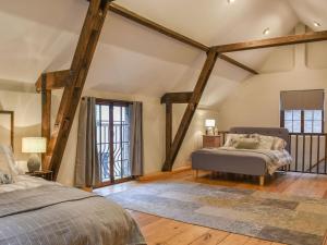 ChipperfieldThe Barn的一间卧室设有两张床和木梁。