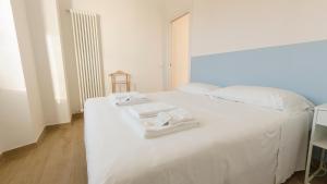 诺利Noliday Riviera Sea View Luxury Apartment的一张白色的床,上面有两条毛巾