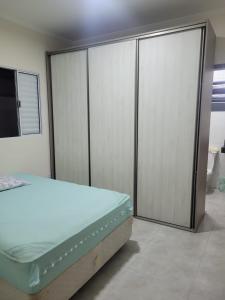 蒙加瓜Bela Mar Mongaguá的一间卧室设有床和滑动玻璃门