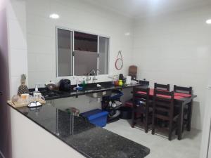 蒙加瓜Bela Mar Mongaguá的厨房配有柜台、水槽和一些椅子
