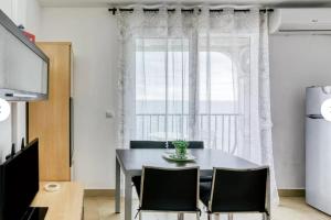 艾姆布里亚布拉瓦Apartamento vistas panorámicas的一间带桌椅和大窗户的用餐室
