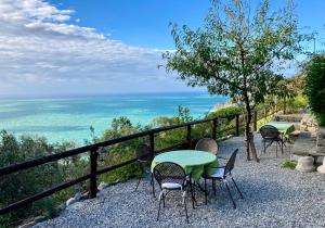 蒙特罗索阿尔马雷Villa Pietrafiore的一张桌子和椅子,背景是大海