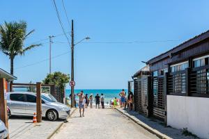 弗洛里亚诺波利斯Predio com apartamentos completos, com piscina e a passos da praia - Agua Marinha的一群人沿着海滩附近的人行道走下