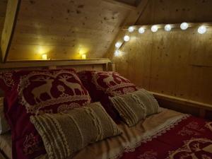 Saint-DiéryLes cabanes féeriques du Cheix的一张床位,房间配有两个枕头和两个蜡烛
