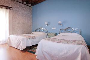 Montemayor de PilillaHOTEL RURAL LOS ABUELOS的蓝色墙壁客房的两张床