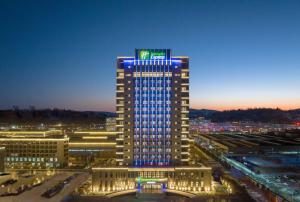 辽源辽源经开区智选假日酒店的一座高大的建筑,上面有蓝色的灯光