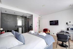 巴黎Couples Getaway Unit with Jacuzzi - City Center的卧室配有一张白色大床和一张书桌