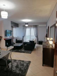 斯巴达Thira Apartment near Athens Airport的客厅配有沙发和桌子